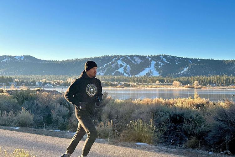 Profiboxer Ronaldo Mancilla joggt auf dem Big Bear Highway während einer Trainingseinheit vor der Kulisse des verschneiten Berges