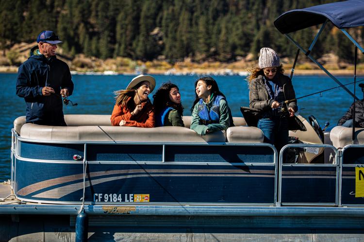 Eine Familie auf einem Ponton genießt einen Angeltag auf dem Big Bear Lake.