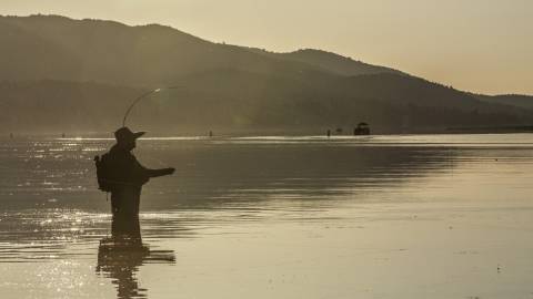 Ein watender Angler wartet geduldig auf seinen Fang am Big Bear Lake