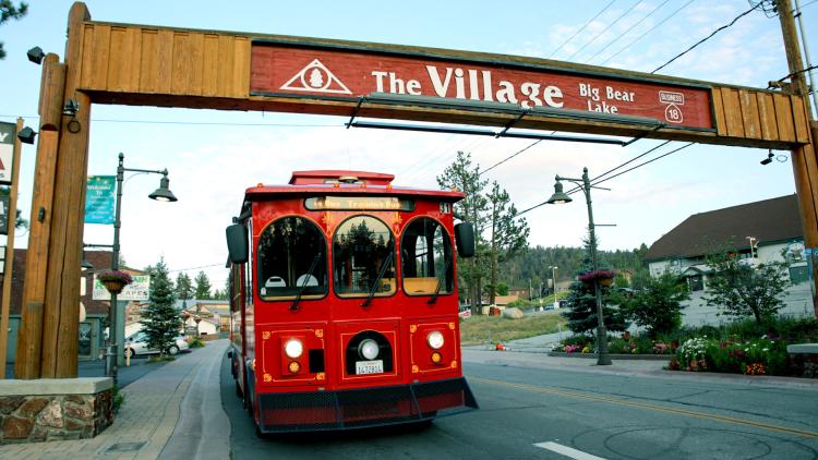 Der Mountain Trolley fährt unter dem "The Village Sign" von Big Bear