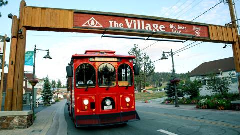 Der Mountain Trolley fährt unter dem "The Village Sign" von Big Bear