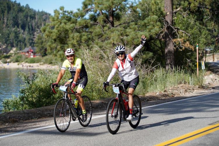 Zwei Radfahrer winken während ihrer Tour de Big Bear in Big Bear Lake, CA