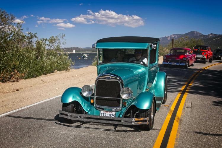 Ein blauer Oldtimer fährt während des Big Bear Fun Run am Wasser des Big Bear Lake entlang.