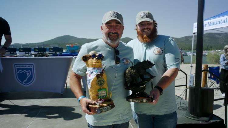 Ein Foto des Gewinners des 1. 2025 FF50K, der Gewinner des ersten Platzes hält eine Trophäe für den ersten Platz und einen Pokal für den größten Fang