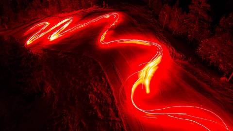 Ein Strom brennender Fackeln beleuchtet eine Skipiste während einer Neujahrsparade in Big Bear, CA. Langzeitbelichtung.