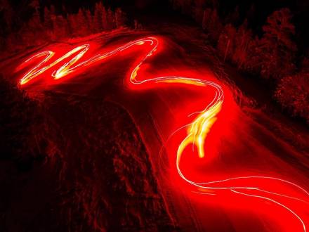 Ein Strom brennender Fackeln beleuchtet eine Skipiste während einer Neujahrsparade in Big Bear, CA. Langzeitbelichtung.
