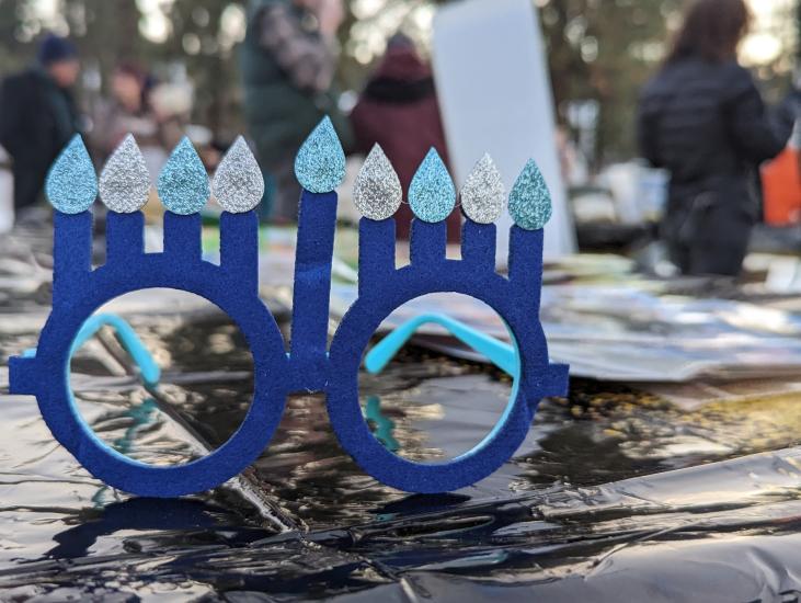 Eine blaue Brille mit acht Chanukka-Kerzen steht auf einem Tisch während einer Chanukka-Feier in Big Bear Lake, CA