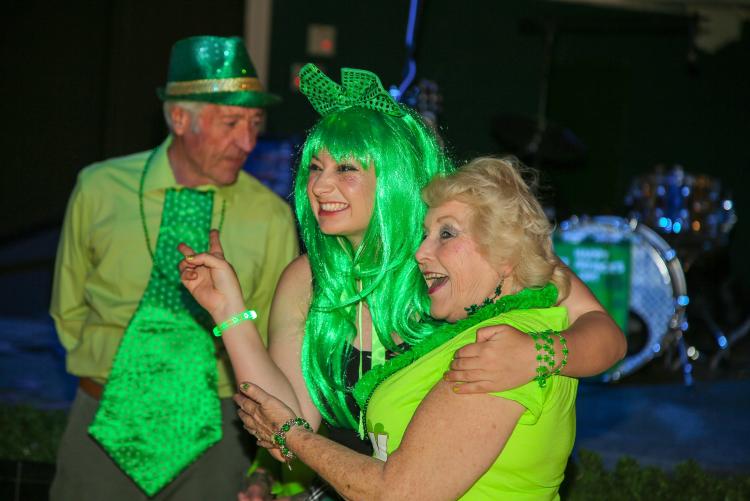 Zwei Frauen posieren für ein Foto während des St. Patrick's Day in Wyatt's Grill & Saloon, sie tragen leuchtend grüne Kostüme.