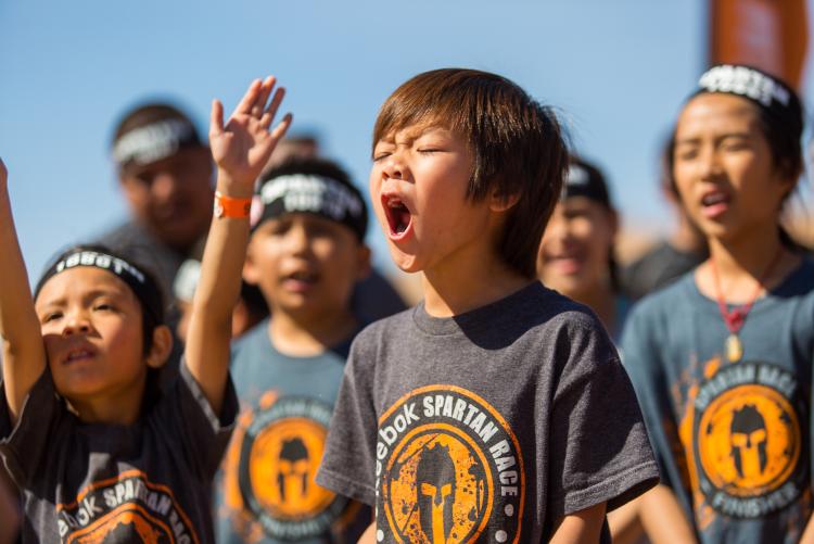 Eine Gruppe junger Kinder in Spartan Race-Shirts feuert die Teilnehmer beim Spartan Trifecta Weekend in Big Bear Lake, CA, an.