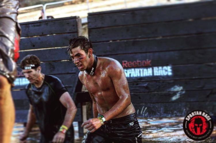 Zwei Spartan-Teilnehmer tauchen während des Spartan Trifecta Weekend in Big Bear Lake, CA, aus einem Wasserhindernis auf.