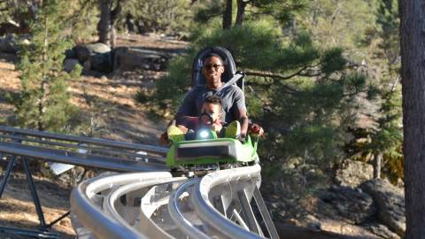 Ein Vater fährt mit seiner Tochter auf dem Mineshaft Coaster in Big Bear, Kalifornien.