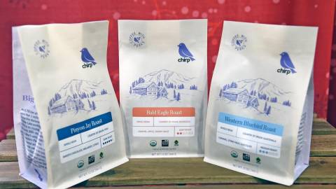 Ein Foto von drei Kaffeesorten von Big Bear Chirp mit Geschmacksrichtungen wie Schokolade, Melasse, Apfel und Karamell.