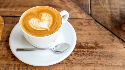 Eine Tasse Kaffee mit schaumiger Kaffeekunst in Form eines Herzens.