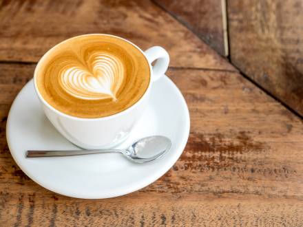 Eine Tasse Kaffee mit schaumiger Kaffeekunst in Form eines Herzens.