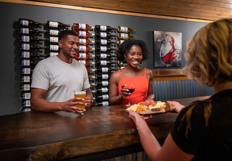 Ein Paar lächelt, als es im Barrel 33 in Big Bear Lake, Kalifornien, einen Aperitif zu seinen Getränken serviert bekommt.
