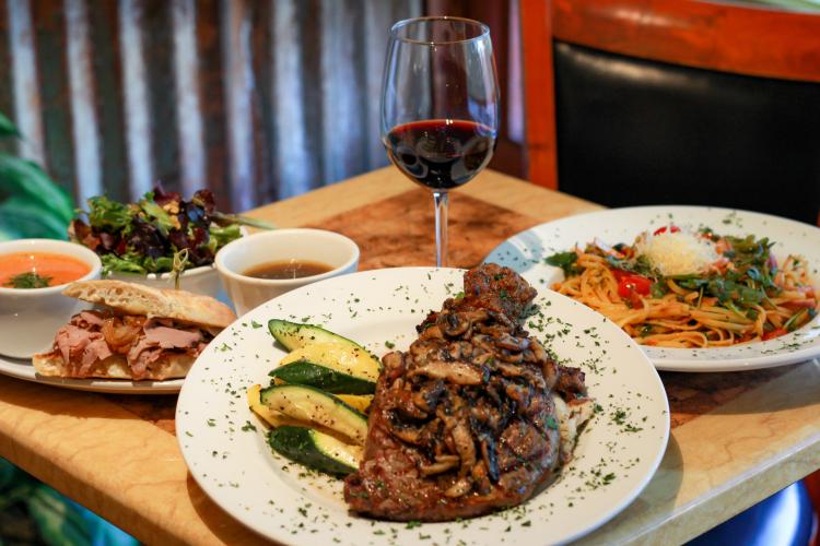 Ein Foto von Sweet Basil Bistro's Fine Dining Optionen, die Gerichte sind Steak, Pasta und ein Sandwich mit Tomatensuppe