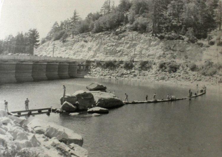 Menschen laufen auf Felsformationen vor dem neuen Big Bear Lake Dam